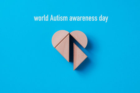 high angle view of some building blocks forming a heart and the text world autism awareness day on a...