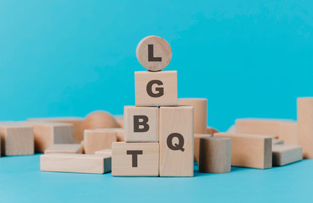 the acronym LGBTQ written in wooden building blocks with different shapes on a blue background, depicting the concept of diversityの写真素材