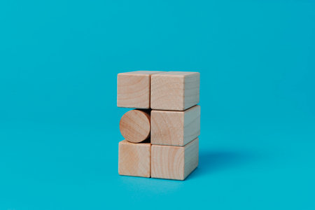 a cylindrical building block in a stack of rectangular building blocks, on a blue backgroundの写真素材