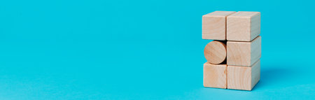 a cylindrical building block in a stack of rectangular building blocks, on a blue background, in a panoramic format to use as web banner or headerの写真素材