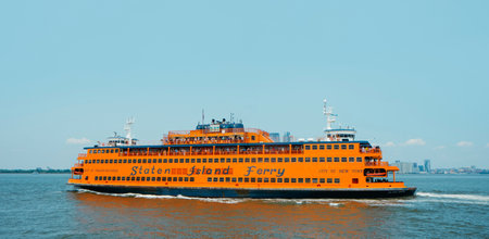 New York City, United States - May 22, 2023: A ferryboat of the Staten Island Ferry browses by the New York Bay, United States, on a sunny spring dayのeditorial素材