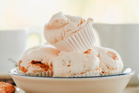 closeup of a white ceramic bowl with some merengues almendrados, baked meringues with almonds, typical of spainの写真素材