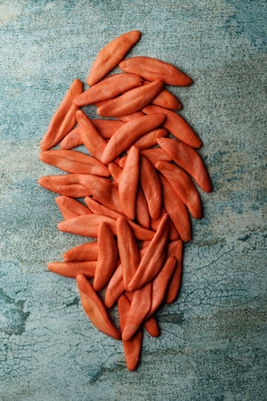 high angle view of some uncooked red foglie di ulivo, an italian pasta in the shape of the olive leaves, on a gray rustic surfaceの写真素材