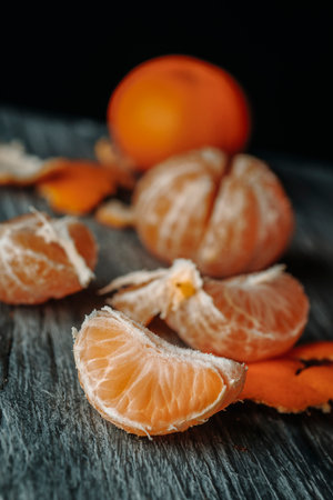 some peeled mandarin oranges on a gray rustic wooden tableの写真素材