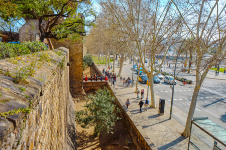 Barcelona, Spain - March 17, 2024: The walls of Les Drassanes Bastion, and Gate of Santa Madrona, in Parallel Avenue in Barcelona, Catalonia, Spainのeditorial素材