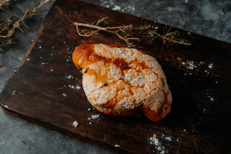 a colomba pasquale, a typical italian easter bread, on a wooden cutting board, placed on a dark rustic tableの写真素材