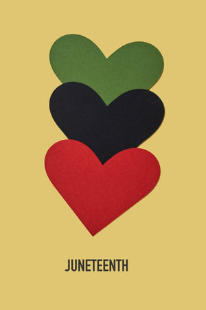 the text juneteenth and three hearts with the colors of the black liberation flag, green, black and red, aka afro-american flagの写真素材