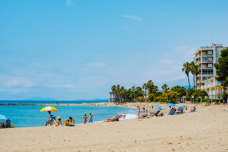 Cambrils, Spain - June 9, 2024: People enjoying the weather of a sunny spring day at Ardiaca Beach in Cambrils, Spain, in the very popular Costa Dorada coast, in the Mediterranean seaのeditorial素材