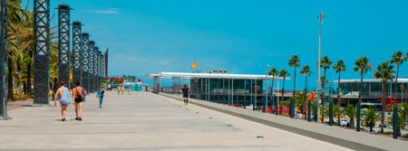 Barcelona, Spain - July 2, 2024: Some people walk and run by the promenade next to the Port Olimpic marina, in Barcelona, Spainのeditorial素材