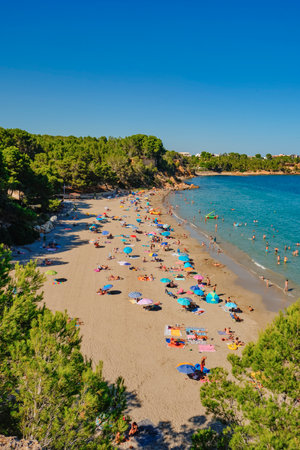 La Ampolla, Spain - July 23, 2024: A view over Cap Roig beach in the Spanish town of La Ampolla, in the popular Costa Daurada coast, with many people enjoying a summer dayのeditorial素材