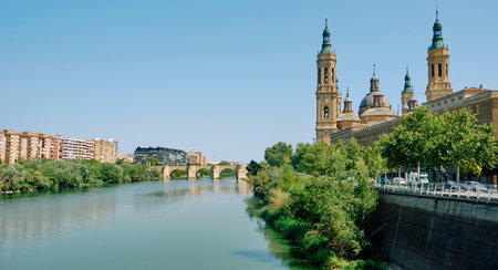 a view of the Ebro River as it passes through Zaragoza, in Spain, with the famous Cathedral-Basilica of Our Lady of the Pillar on the rightの写真素材