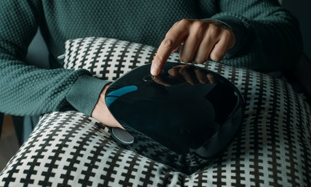 closeup of a man, in casual clothes, using a hand massager while is sitting indoorsの写真素材