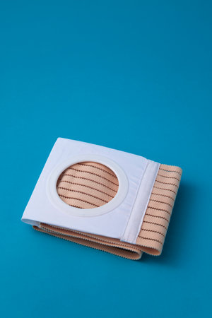 a folded abdominal belt with a stoma opening for colostomy patients on a blue backgroundの写真素材