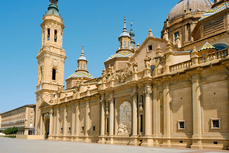 a view of the facade of the Cathedral-Basilica of Our Lady of the Pillar, in Zaragoza, Spain, on a sunny summer dayの写真素材
