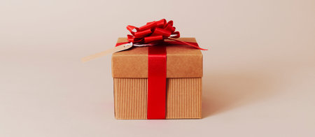 a brown gift box, tied with red ribbon and topped with a red ribbon bow, with a paper tag attached...