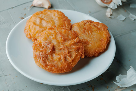 some spanish tortas de camaron, shrimp cakes, on a white ceramic plate, on a textured gray concrete surfaceの写真素材
