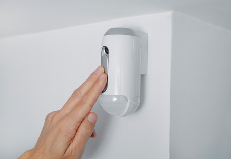 closeup of a man connecting the camera of a burglar alarm equipped with a motion detector, indoorsの写真素材