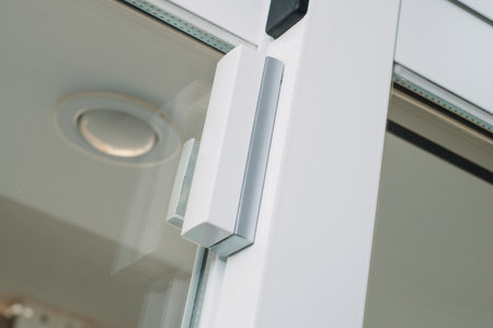 a wireless glass break detector and contact breaker on a window, as part of a burglar alarm systemの写真素材