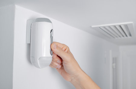 a man connects the camera of an alarm system equipped with a motion detectorの写真素材