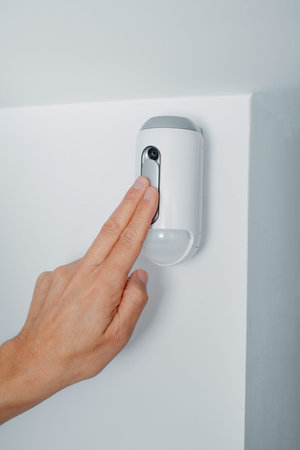 closeup of a man connecting the camera of a burglar alarm system equipped with a motion detector