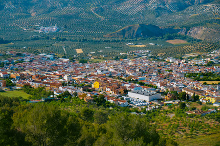 from above, Cuevas de San Marcos appears as a small Andalusian town in Malaga Province, ringed by mountains and olive fieldsの写真素材