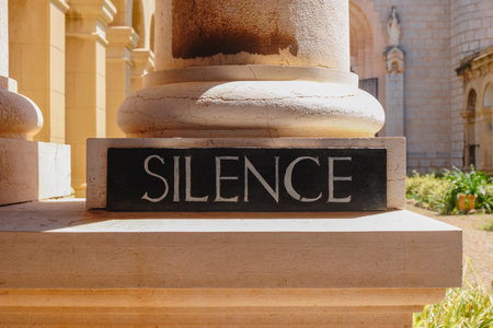 a black sign with the word silence at the courtyard of the Lerins Abbey, in Saint-Honorat island, Franceの写真素材