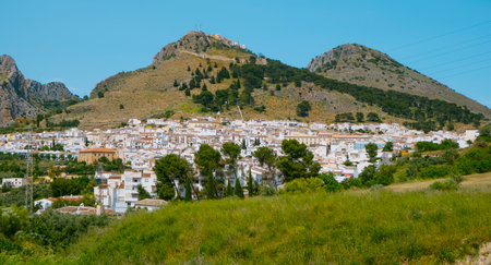 a view over Archidona, a small town at the base of a mountain, in Malaga province, Spain, on a sunny spring day, seen from the distanceの写真素材