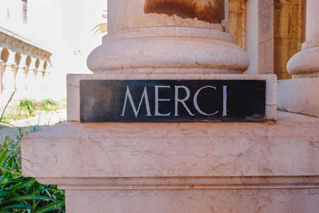 a black sign with the word merci, the french word for thank you, at the courtyard of the Lerins Abbey, in Saint-Honorat island, Franceの写真素材