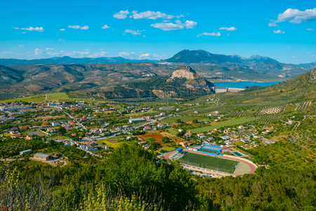 aerial view of scattered houses and olive groves in the countryside of Cuevas de San Marcos, Spain, with the town of Rute visible in the distance and the Iznajar reservoir dam appearing to the rightの写真素材