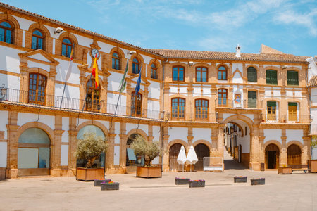 the city hall of Archidona, Spain, seen on the left with a clock on the upper part of its facade,...