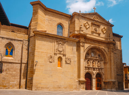 facade of the Cathedral of Santo Domingo de la Calzada in La Rioja, Spain, with its ornate entrance and stone carvings under a bright blue summer skyの写真素材
