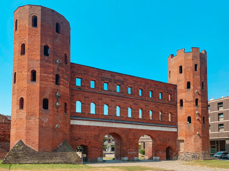 frontal view of the Porta Palatina in Turin, Italy, highlights the Roman gate with twin towers and multiple windows, a lasting symbol of the city of the ancient Roman Empireの写真素材