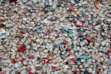 abstract composition of hundreds of used chewing gums pressed onto a city wall, creating a dense mosaic of color spots and irregular organic shapesの写真素材
