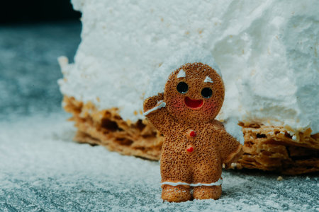 a lone gingerbread man stands proudly in front of a mound of meringue milhojas and powdered sugar, his joyful smile brightening the winter atmosphereの写真素材