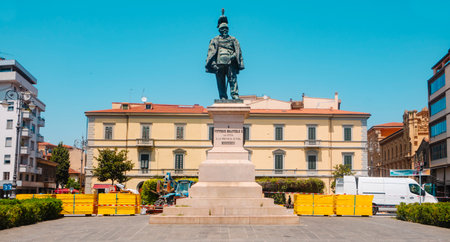 Pisa, Italy - June 26, 2025: A wide view of Piazza Vittorio Emanuele II shows the statue of the former king rising above the square, with surrounding buildings and street activity in midday lightのeditorial素材