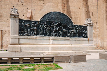 the Giuseppe Verdi monument displays a dramatic bronze relief of musicians and figures, set against the tall brick wall of the Palazzo della Pilottaのeditorial素材