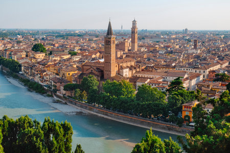 from an elevated viewpoint, Verona stretches around the Adige River, with the bell tower of the Basilica di Sant Anastasia emerging clearly among the densely packed terracotta rooftopsの写真素材