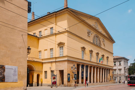 Parma, Italy - June 25, 2025: A frontal perspective of the Teatro Regio di Parma highlights its portico of stone columns, the sculpted pediment and the row of upper windowsのeditorial素材