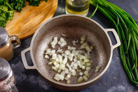 2. Cut the onion into small cubes and fry in a cauldron for 2-3 minutes, pouring in vegetable oil.