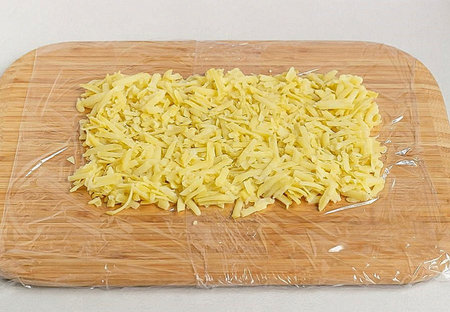 2. Cover the board with cling film, on it we will spread the salad in the form of a rectangle. 1...