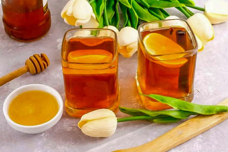 Pour hot grog into glasses and stir in honey in each of them, waiting for the drink to cool down to 40 degrees. Serve to the table.の写真素材