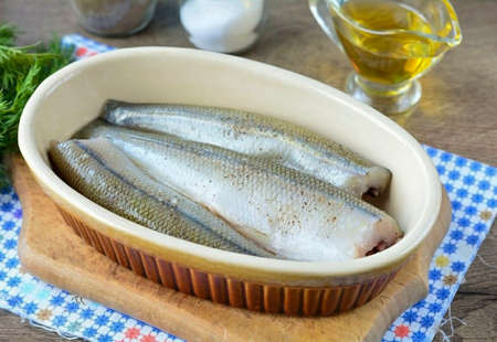 Grease the dish with oil, put the fish.の写真素材