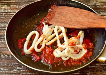 Then lay out the prepared squid rings. Mix everything well.の写真素材