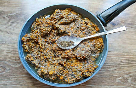 Add black pepper to the mushroom mixture and stir.の写真素材