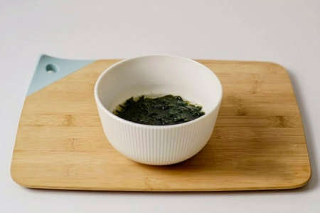 Pour hot water over the wakame seaweed, add the fish seasoning, leave for 5 minutes. Then strain the resulting liquid.の写真素材