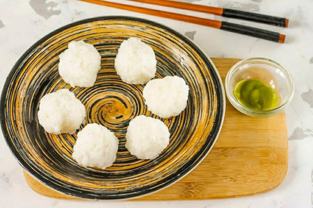 While wetting your hands in water, pinch off some of the rice and form a ball in your palms. Thus, prepare a few more blanks.の写真素材