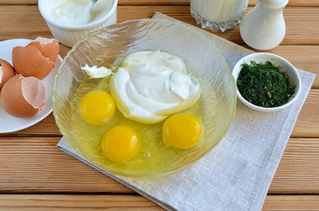 Get a container that is convenient for mixing and a whisk or mixer. Break eggs, pour in sour cream.の写真素材