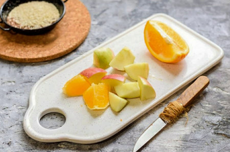 Peel the orange, remove the peel and seeds. Cut the apple into small wedges.の写真素材