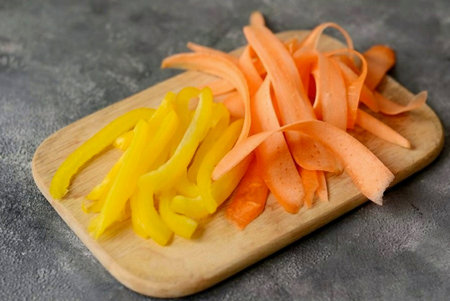 Cut the carrots into thin strips and the bell peppers into strips.