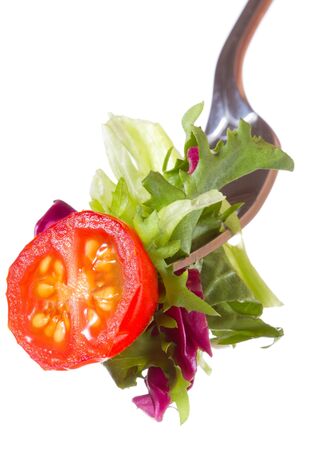 fork with tomato and greens on white backgroundの写真素材